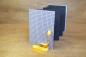 Preview: Leporello standing, black zig-zag pages, yellow ribbon